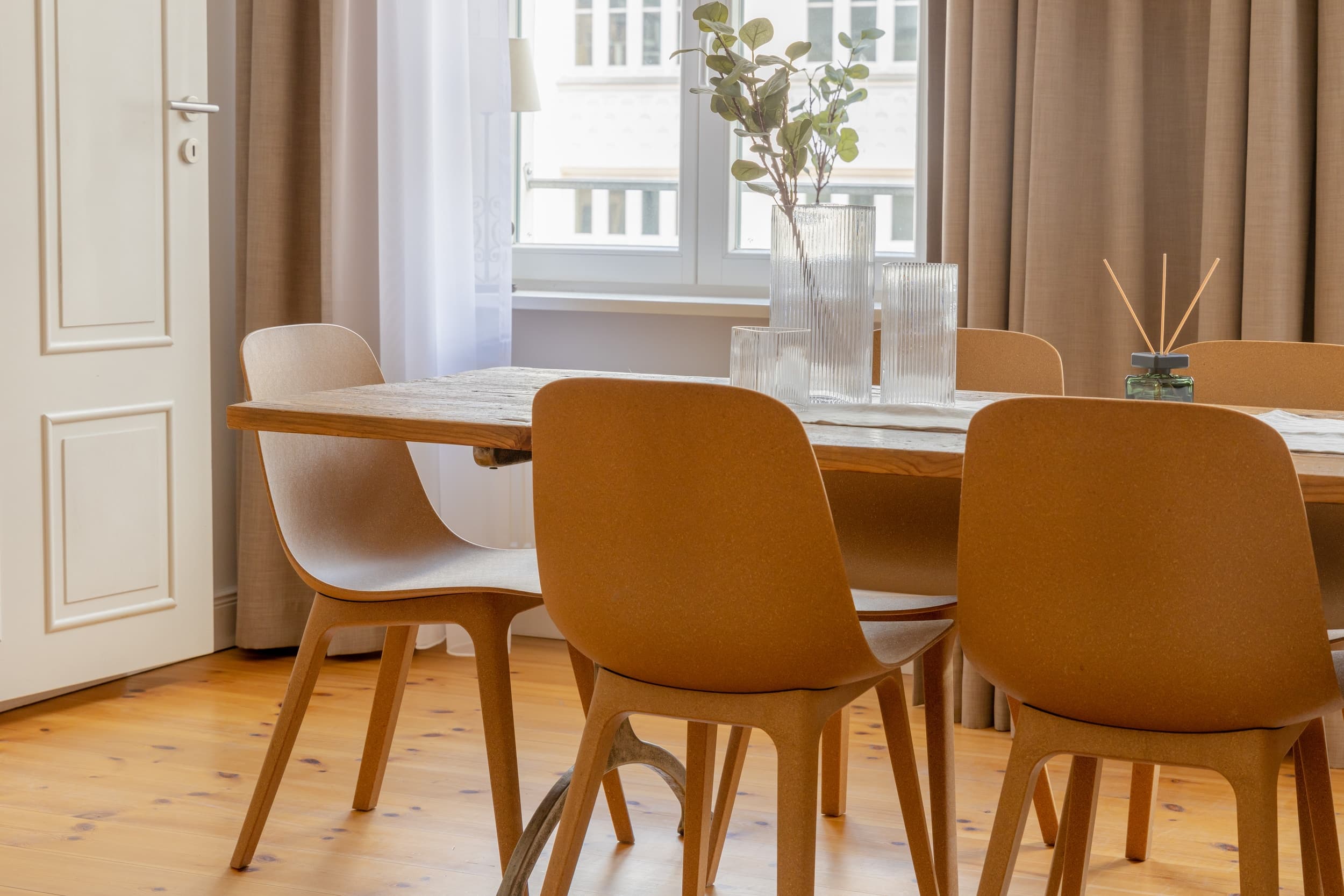 A prepared dining table with warm ochre chairs